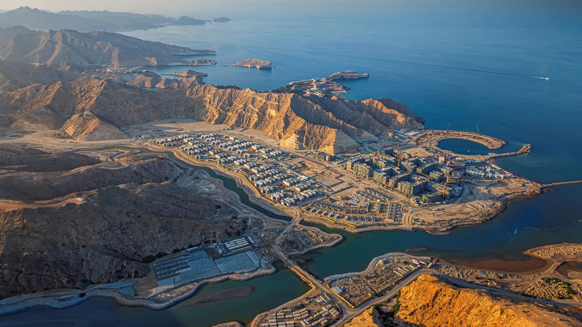 Aerial view of The Sustainable City Yiti between the Hajar mountains and the Gulf of Oman