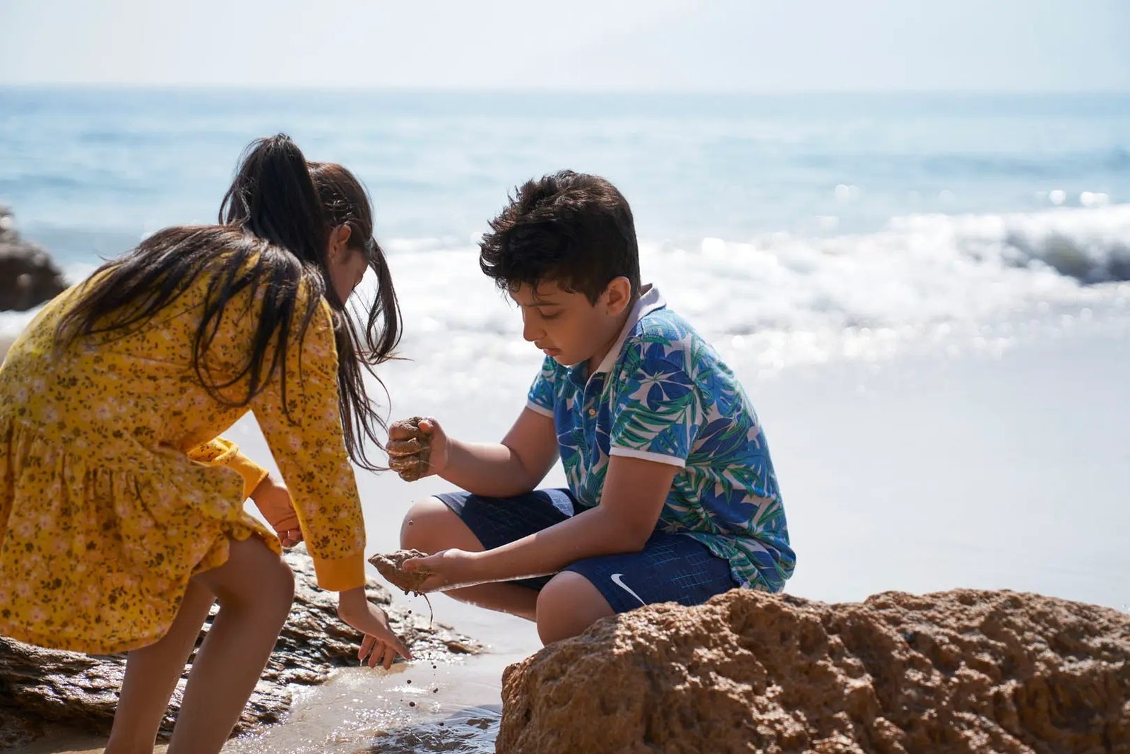Children playing by the rocks on the Yiti shoreline