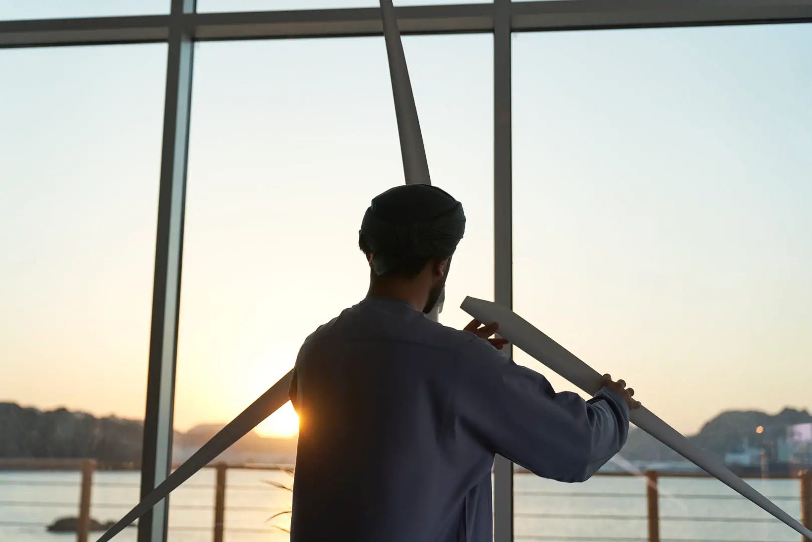 Resident on a balcony looking at the sea at sunset
